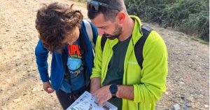Local English-speaking guide explaining the route and wildlife map to a traveler during a guided nature excursion from Sofia.